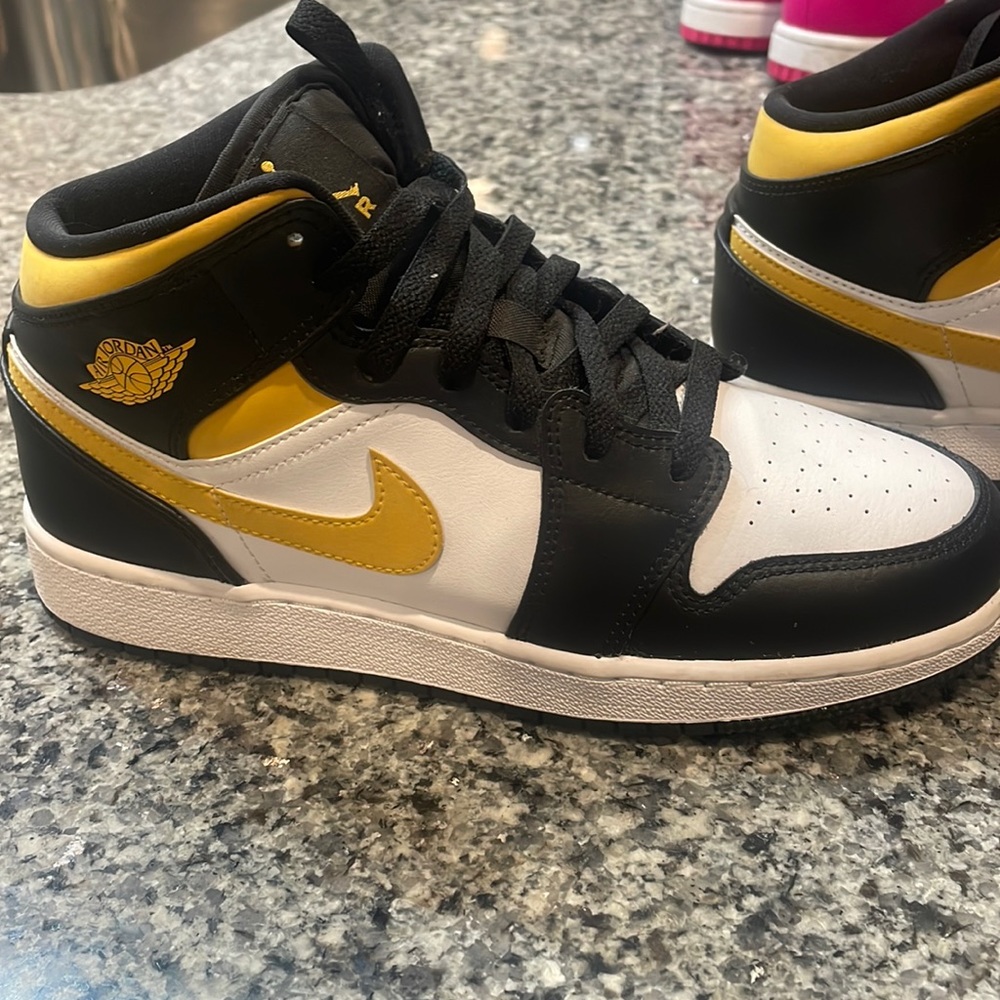 Nike black and yellow Jordan mids